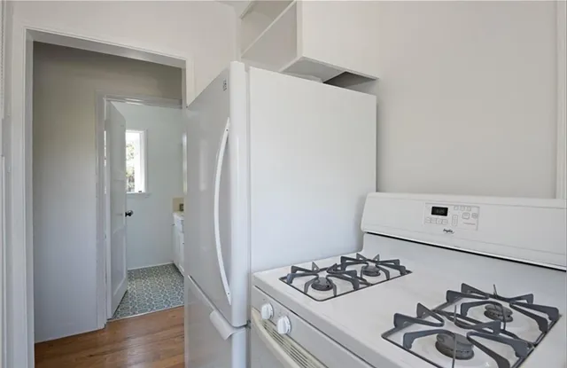 a white stove top oven sitting inside of a kitchen
