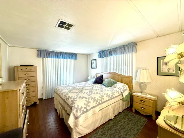 a spacious bedroom with a bed and wooden floor