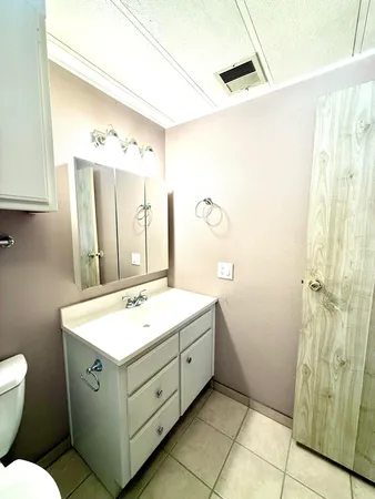 a bathroom with a sink mirror toilet and shower