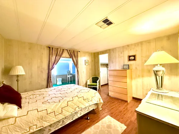 a bedroom with a bed and a flat tv screen on dresser