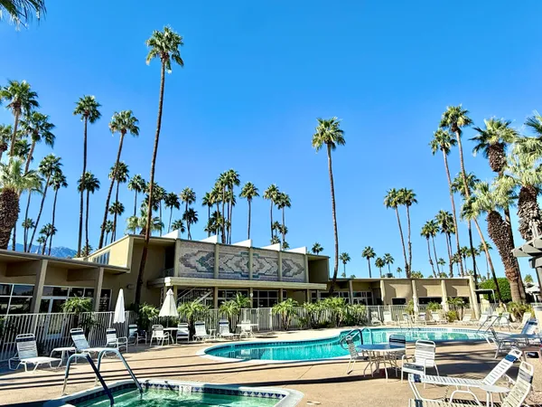 a view of a swimming pool and a table and chairs in patio