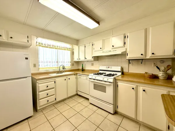 a kitchen with granite countertop cabinets and white stainless steel appliances