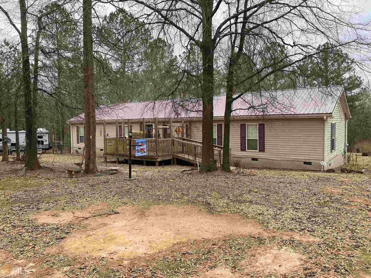 a view of a house with a yard covered in forest