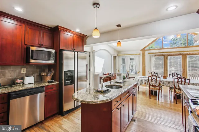 a kitchen with stainless steel appliances granite countertop a sink a stove and a refrigerator