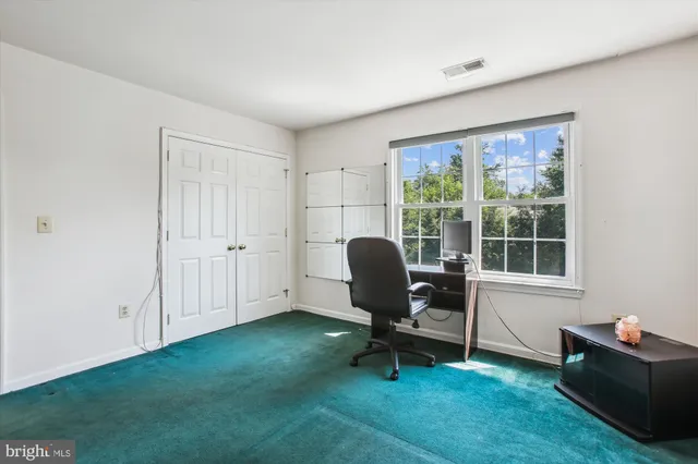 a view of a workspace with furniture and a window