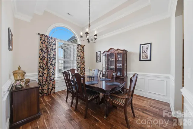a view of a dining room with furniture wooden floor and chandelier