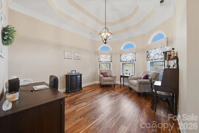 a living room with furniture a chandelier and a wooden floor