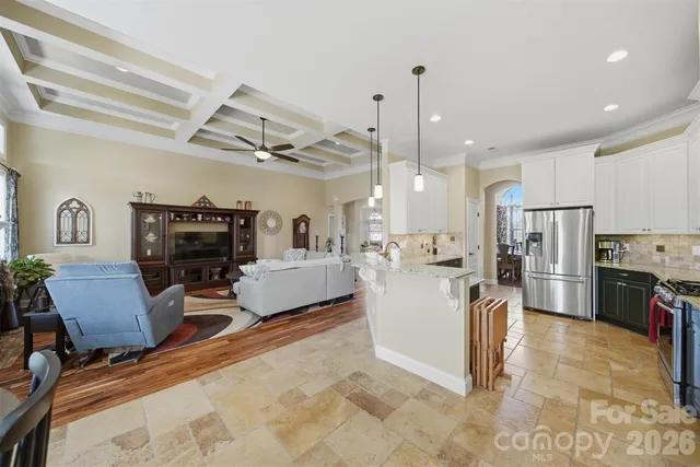 a living room with furniture a flat screen tv and kitchen view