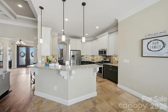 a large kitchen with stainless steel appliances granite countertop a stove and refrigerator