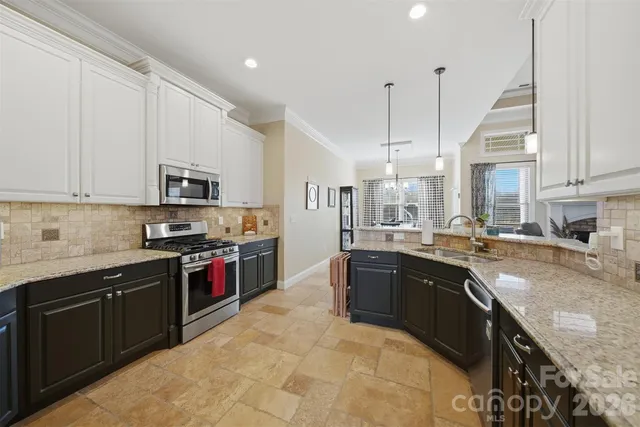 a large kitchen with stainless steel appliances granite countertop a sink a stove and a granite counter top