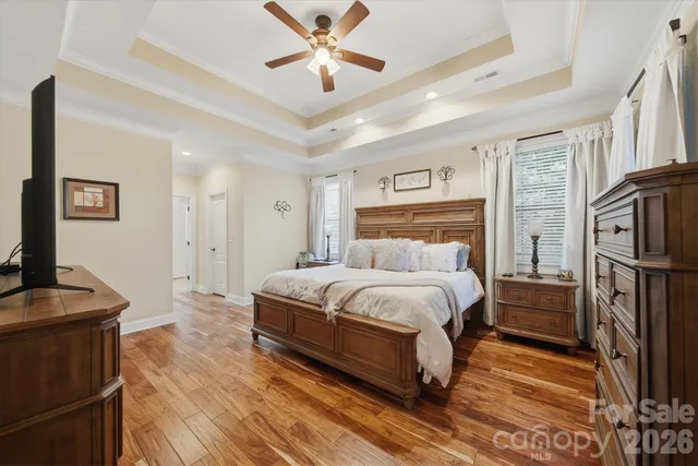 a spacious bedroom with a bed and a flat screen tv