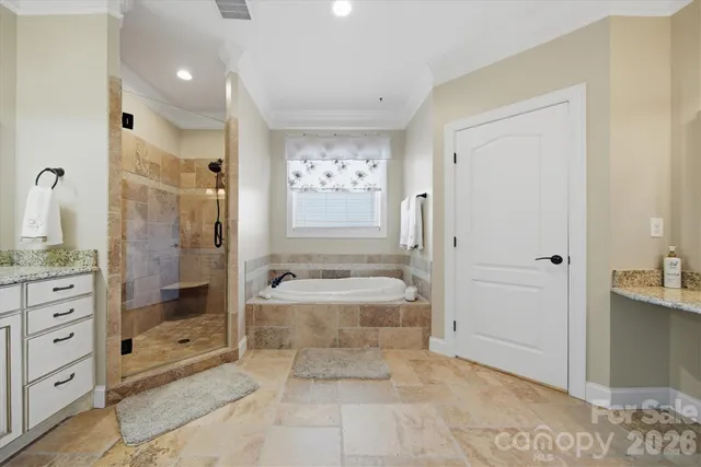 a bathroom with a granite countertop sink a mirror a bathtub and shower