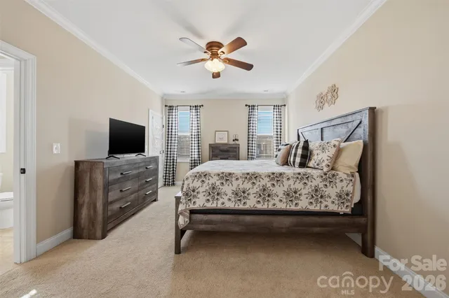 a bedroom with a bed and a flat tv screen on dresser