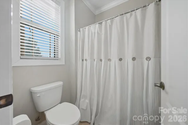 a white toilet sitting next to a shower curtain