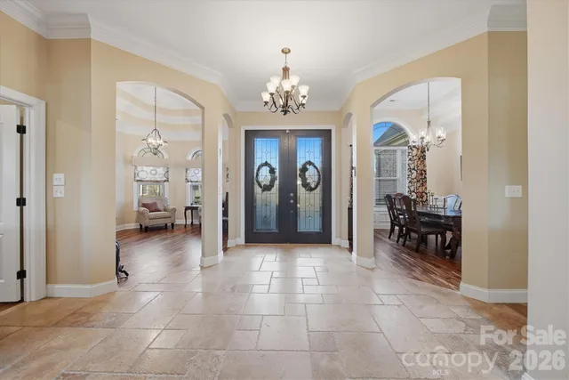a view of a livingroom kitchen and dining room with chandelier