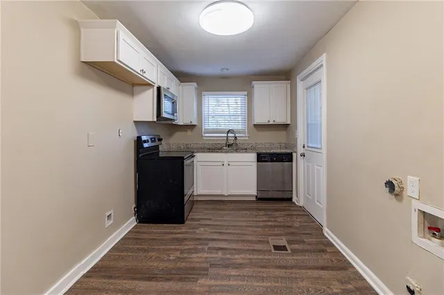 a kitchen with granite countertop a refrigerator and a sink