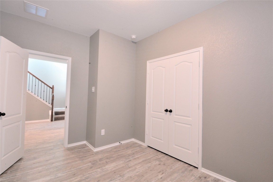 522 Thunder Valley Trail Georgetown, TX 78626 - Photo 11 of 24 an empty room with wooden floor and mirror
