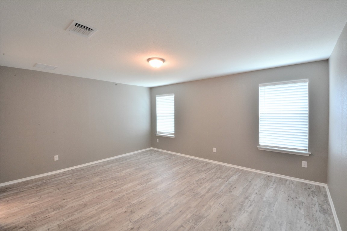 522 Thunder Valley Trail Georgetown, TX 78626 - Photo 14 of 24 a view of an empty room with wooden floor and a window