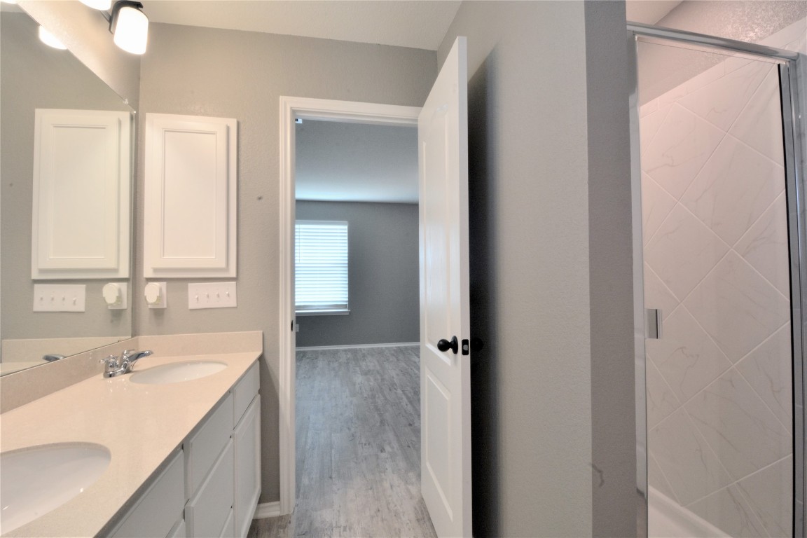 522 Thunder Valley Trail Georgetown, TX 78626 - Photo 17 of 24 a bathroom with a double vanity sink a mirror and a shower