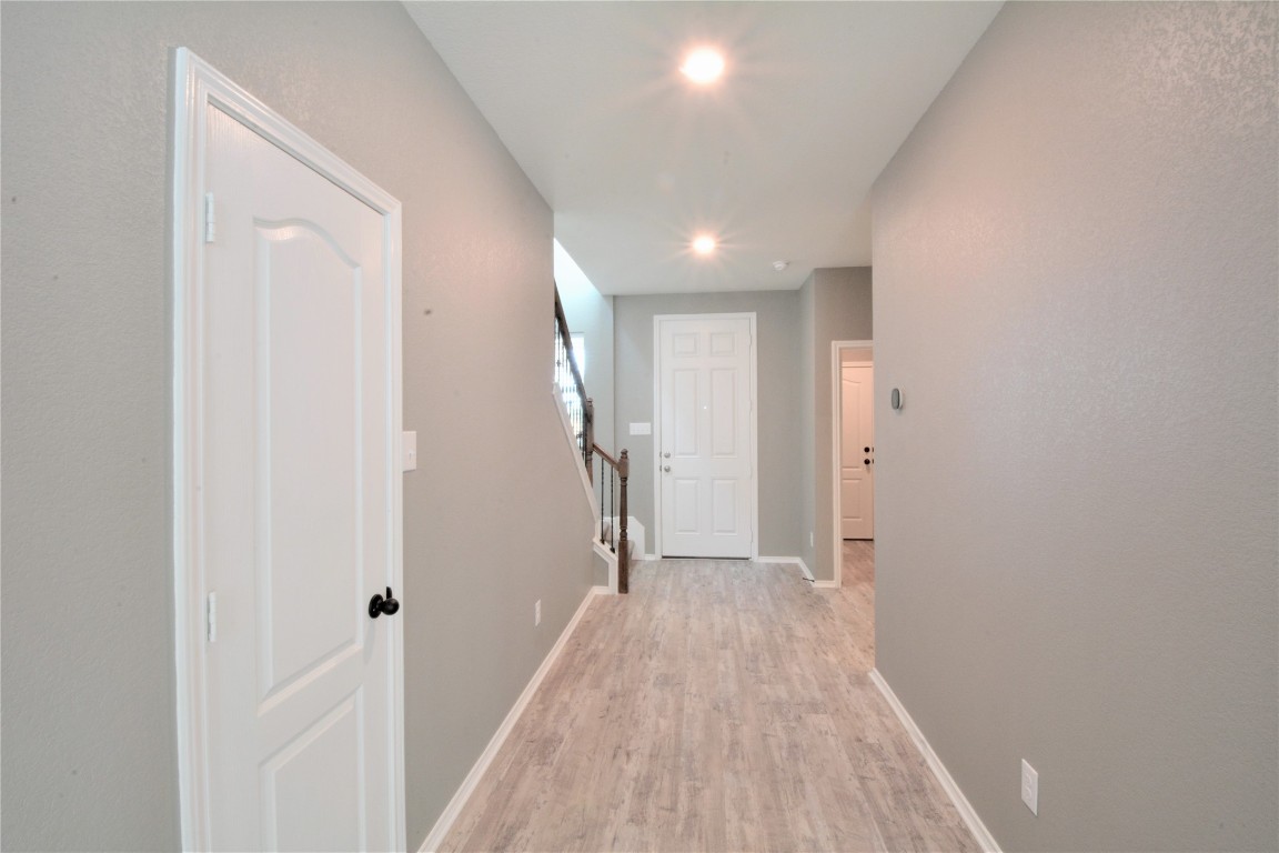 522 Thunder Valley Trail Georgetown, TX 78626 - Photo 3 of 24 a view of a hallway with wooden floor and a bathroom