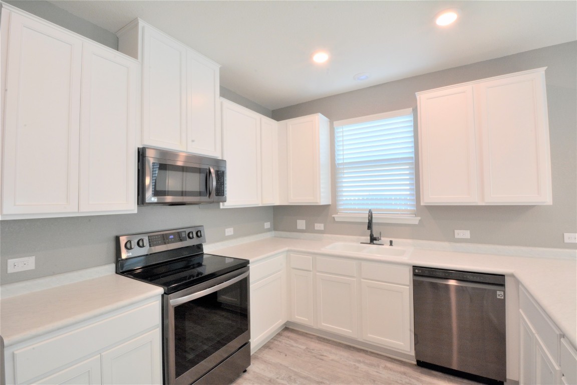 522 Thunder Valley Trail Georgetown, TX 78626 - Photo 7 of 24 a kitchen with a sink stove top oven and cabinets