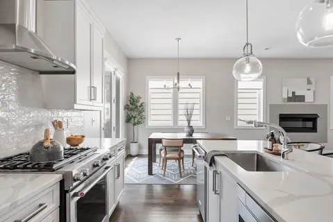 a kitchen with a stove a sink a window and cabinets