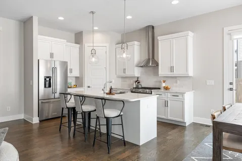 a kitchen with stainless steel appliances granite countertop a table chairs stove a sink and a refrigerator