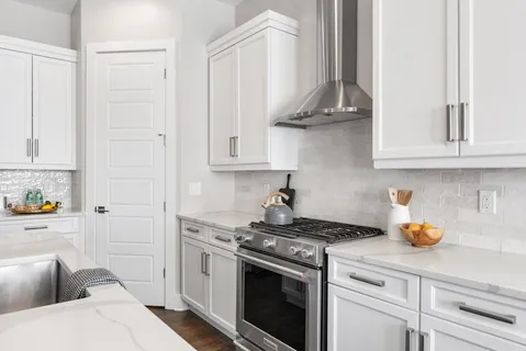 a kitchen with stainless steel appliances granite countertop a sink a stove and cabinets