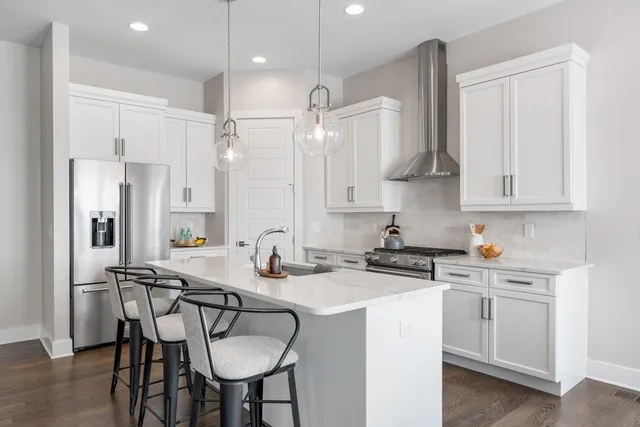 a kitchen with stainless steel appliances a sink a stove a refrigerator and cabinets