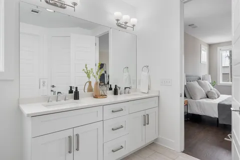a en suite bathroom with 2 sink flowerpot and a mirror