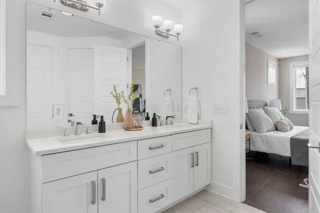 a en suite bathroom with 2 sink flowerpot and a mirror