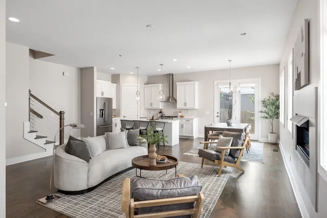 a living room with furniture kitchen view and a large window