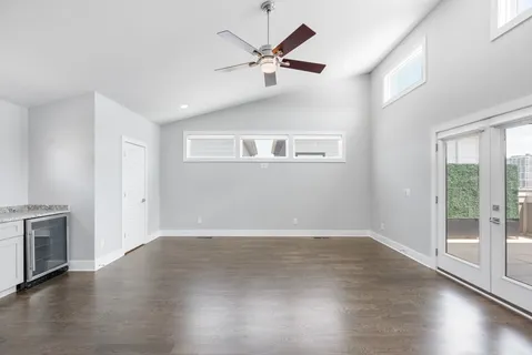 a view of an empty room with a ceiling fan and wooden floor