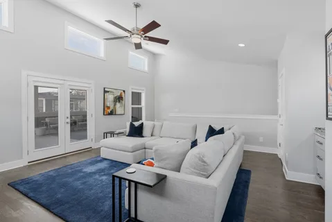 an empty room with windows and ceiling fan