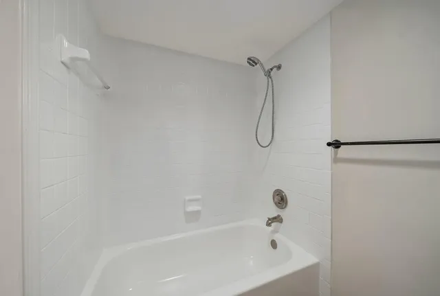 a bathroom with a bath tub with a shower