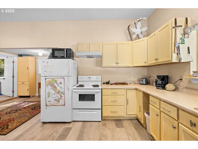 a kitchen with cabinets appliances and wooden floor