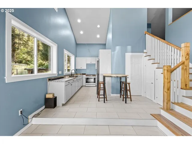 a living room with stainless steel appliances kitchen island granite countertop furniture and a large window