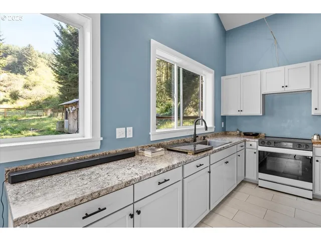 a kitchen with granite countertop a sink and a stove