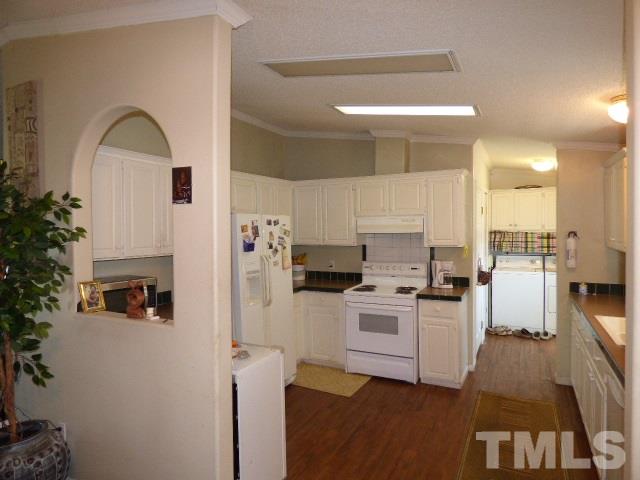 3855 Reedy Prong Church Road Dunn, NC 28334 - Photo 11 of 25 a kitchen with white cabinets and black appliances