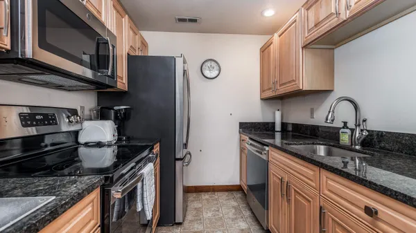 a kitchen with stainless steel appliances granite countertop a sink stove and refrigerator