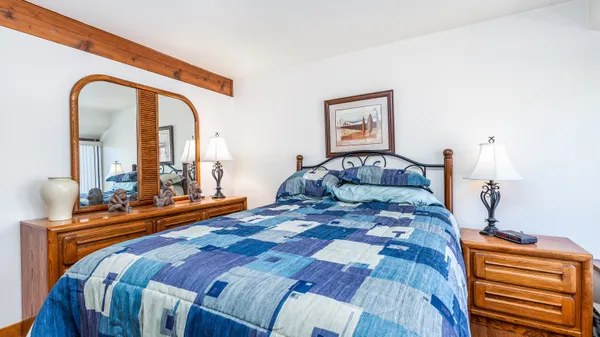 a bedroom with a bed and a mirror on dresser