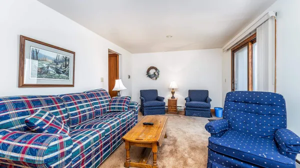 a living room with furniture a couch and a large window