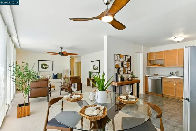 a living room with furniture kitchen view and a chandelier