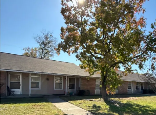 front view of a house with a large tree