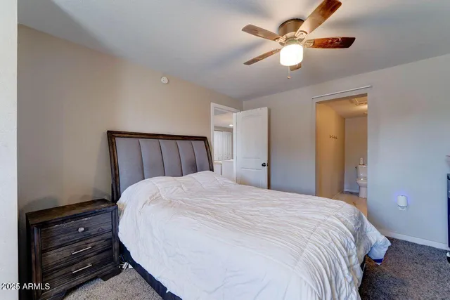 a bedroom with a bed and a ceiling fan