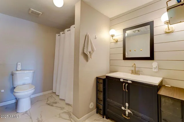 a bathroom with a toilet sink and mirror
