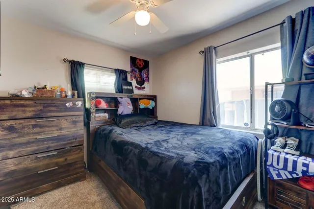 a bedroom with a bed and large windows