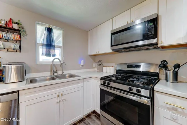 a kitchen with cabinets stainless steel appliances and a sink