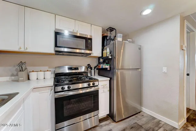 a kitchen with stainless steel appliances granite countertop a refrigerator stove and sink