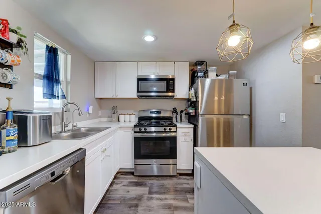 a kitchen with a sink stainless steel appliances and counter space